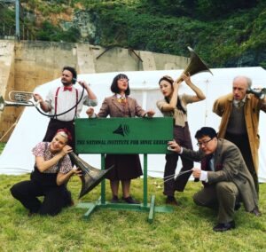 The cast of Ear Trumpet posing in front of the site tent